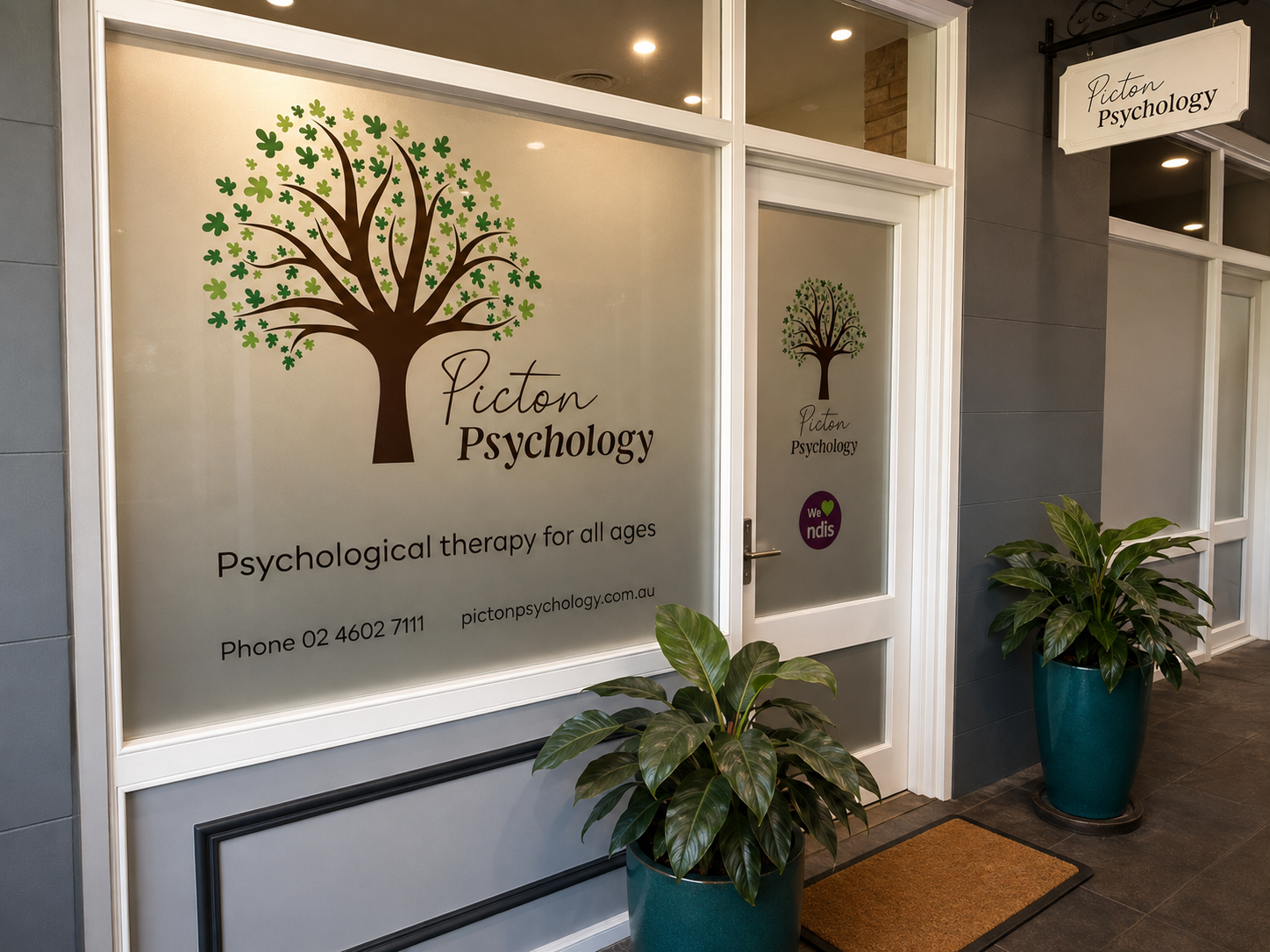 The Picton Psychology shopfront on Argyle Street, with the branded tree logo on frosted glass and potted plants at the entrance